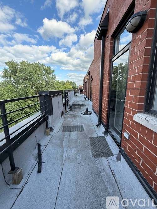 A balcony with a metal railing and brick building.