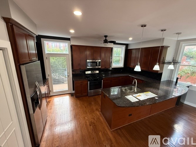 A kitchen with wooden cabinets and a black countertop.