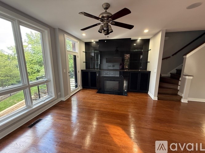 A room with a ceiling fan and a fireplace.