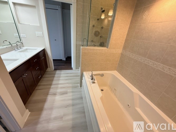 A bathroom with a tub, sink, and shower.