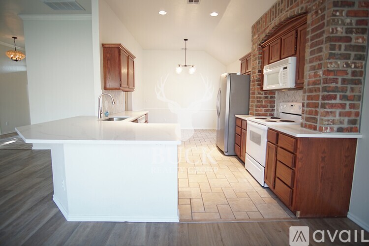 A kitchen with a white island and wooden cabinets.