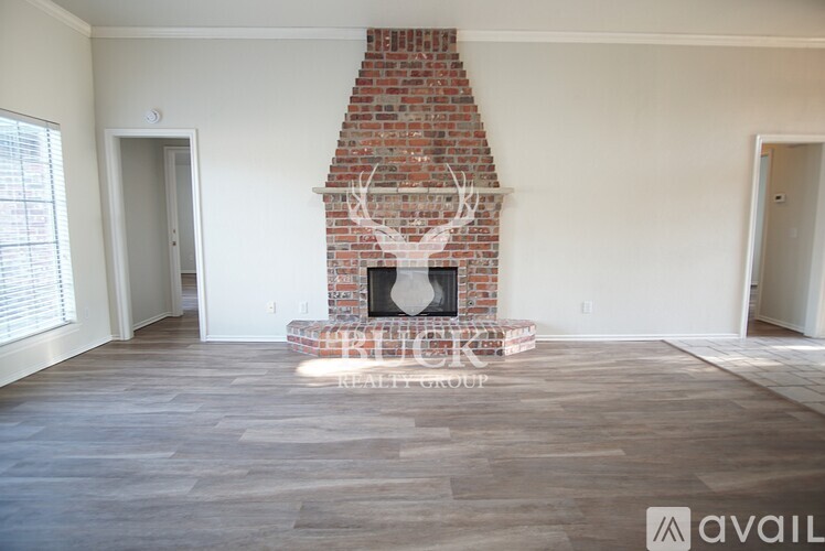 A room with a brick fireplace and wooden flooring.