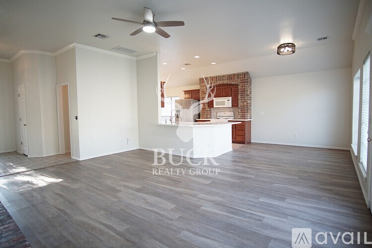 A room with a ceiling fan and a brick fireplace.