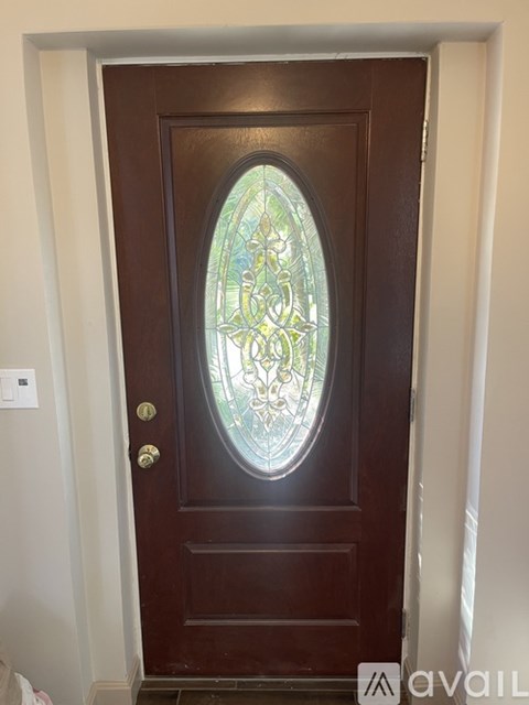 A brown door with a glass window in the middle.