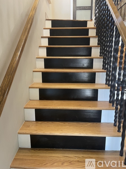 A wooden staircase with black risers and white treads.