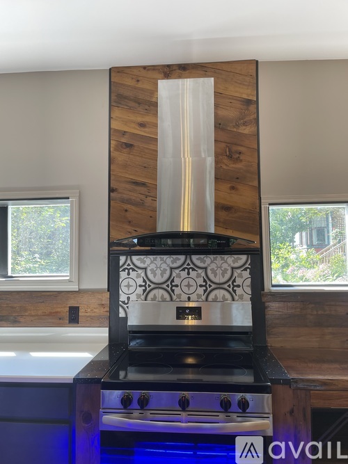 A modern kitchen with a wood grain wall and a black stove top oven.