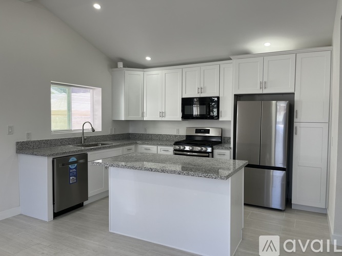 A modern kitchen with granite countertops and stainless steel appliances.