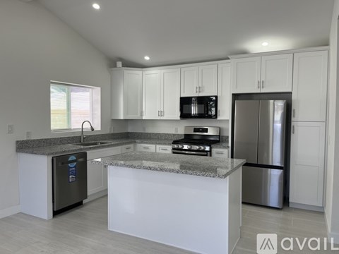 A modern kitchen with granite countertops and stainless steel appliances.