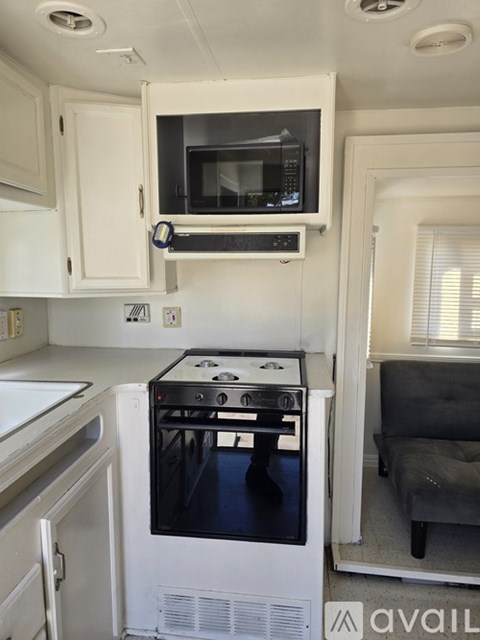 A small kitchen with a microwave and oven built into the cabinetry.