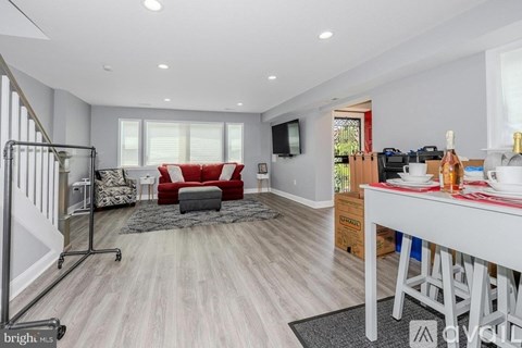 A modern living room with a red couch and a television mounted on the wall.