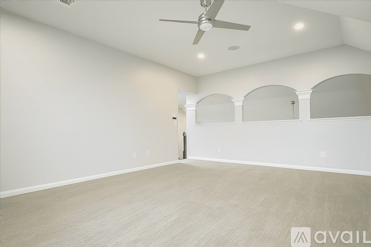 A room with a ceiling fan and lighting fixtures.