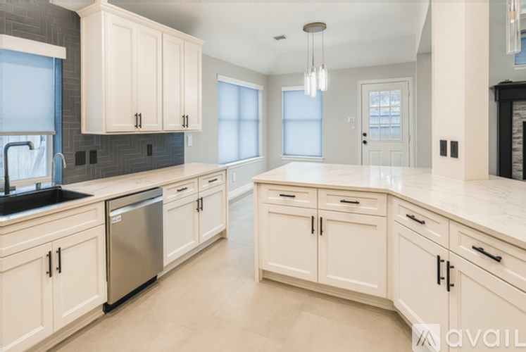 A kitchen with white cabinets and a black countertop.