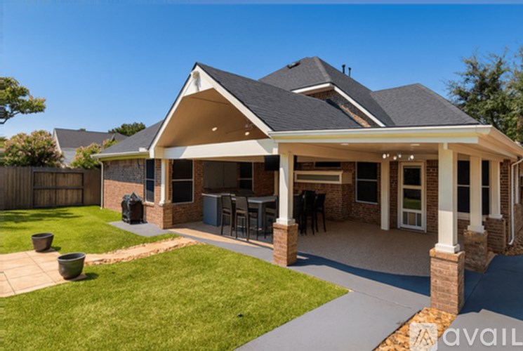 A house with a covered patio and a lawn.