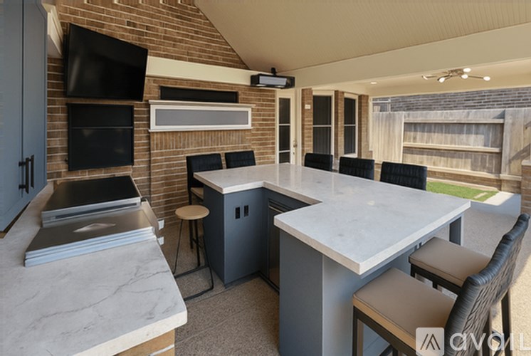 A kitchen with a table and chairs and a television.
