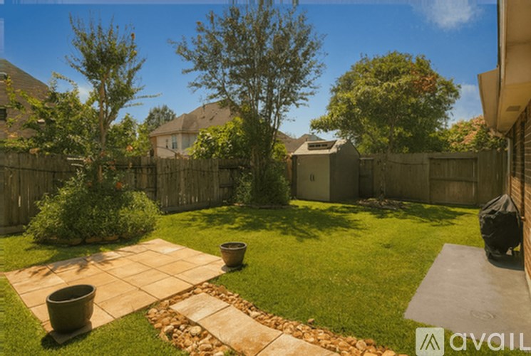 A backyard with a patio, a fire pit, and a trash can.