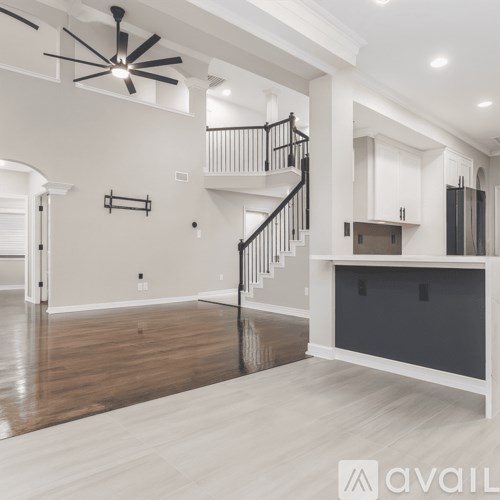 A spacious living room with a staircase leading to the upper floor.