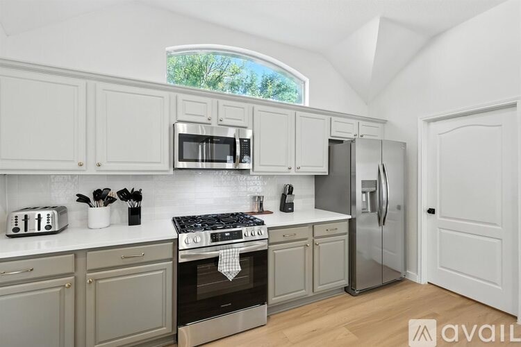 A kitchen with white cabinets and a stove top oven.