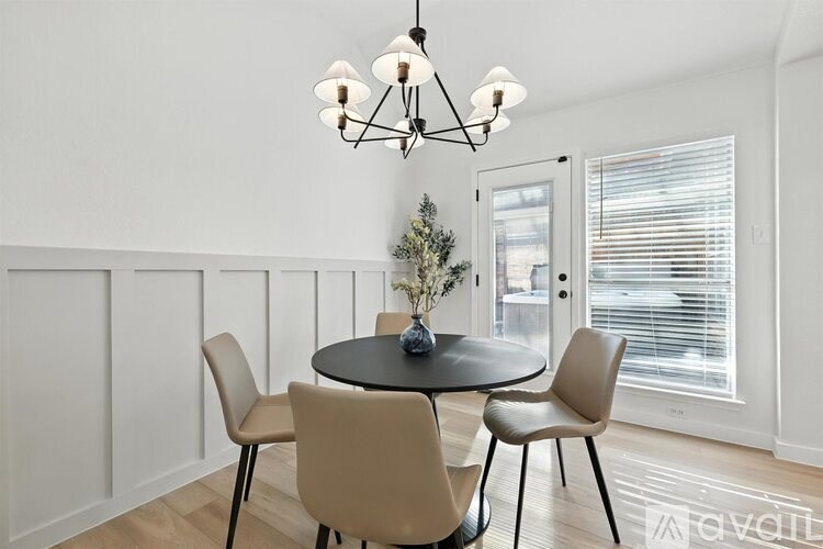 A modern dining room with a round table and chairs.