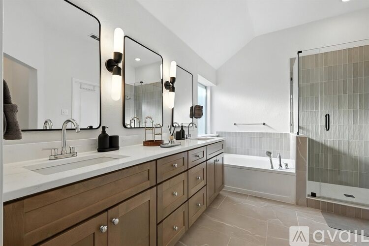 A bathroom with a large mirror, a sink, and a bathtub.