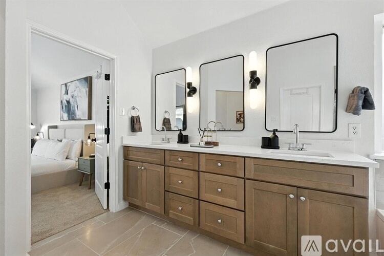 A bathroom with a vanity, a mirror, and a bed.