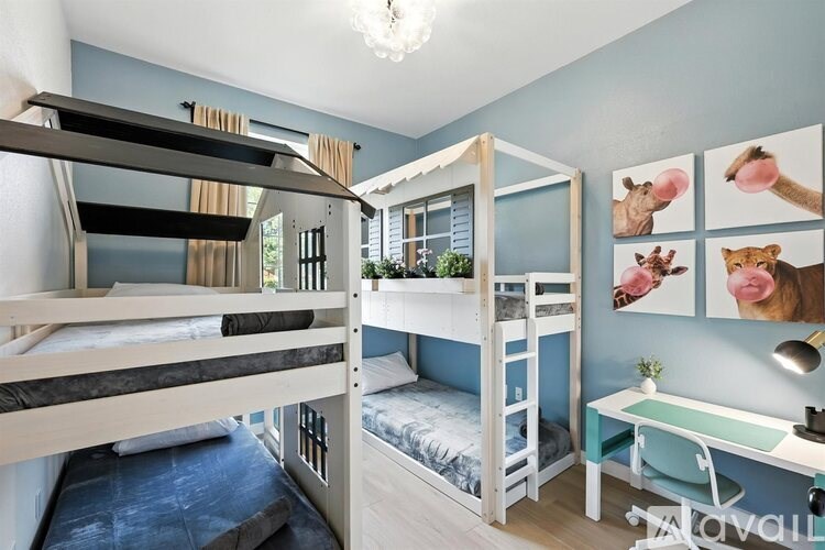 A room with bunk beds and a desk with drawings of animals on the wall.