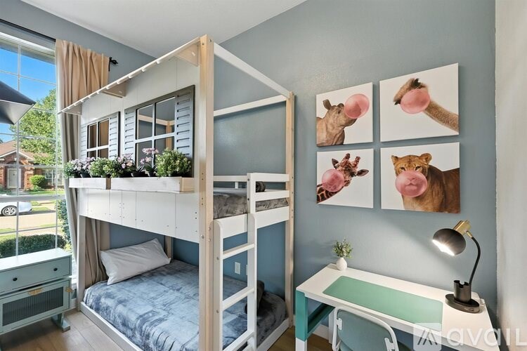 A room with a bunk bed and a desk with a lamp on it.