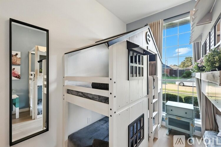 A room with bunk beds and a mirror on the wall.
