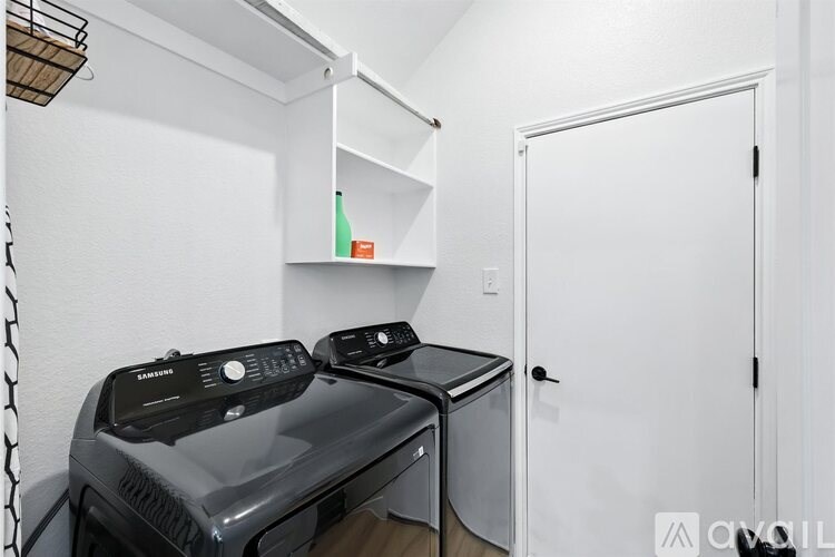A black and silver printer sits on a desk in a white room.