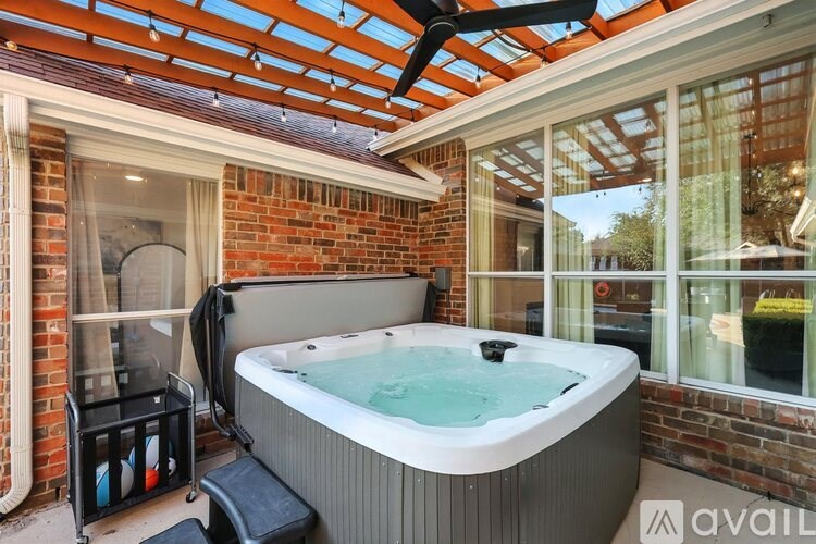 A hot tub is in the middle of a room with a glass ceiling.
