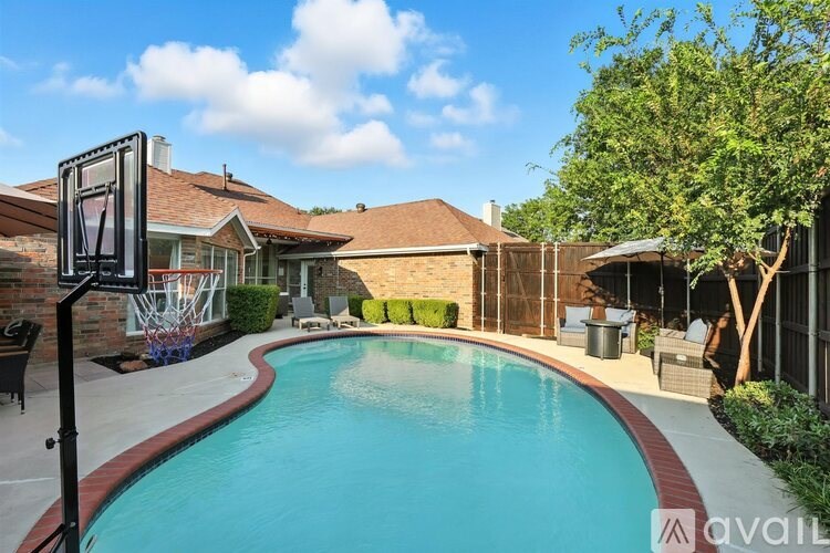 A pool surrounded by a fence and trees.
