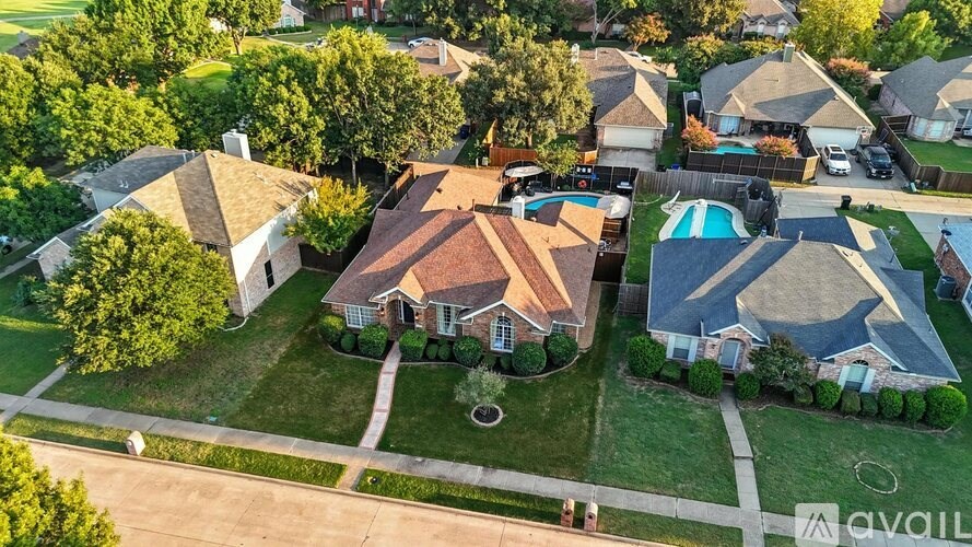 A bird's eye view of a suburban neighborhood with houses and a pool.