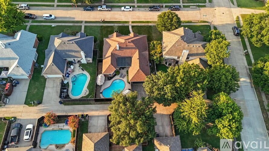 A bird's eye view of a neighborhood with houses and swimming pools.