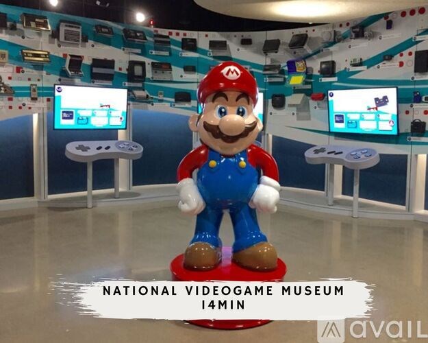 A statue of Mario stands in the middle of a room with multiple monitors in the background.