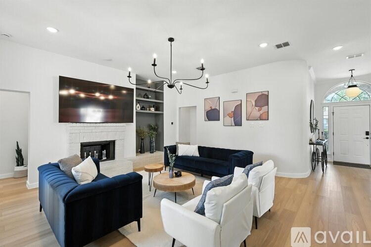 A living room with a dark blue couch and a fireplace.