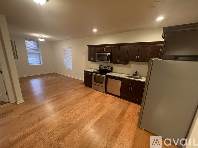 A kitchen with wooden floors and a refrigerator.