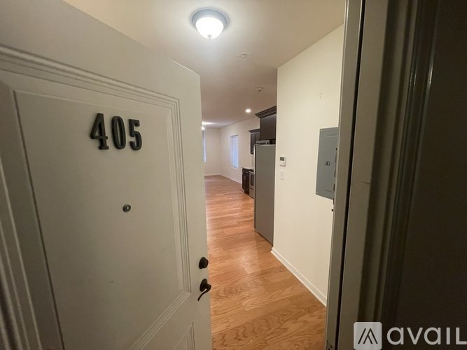 A hallway with a door numbered 405 and a light on the ceiling.