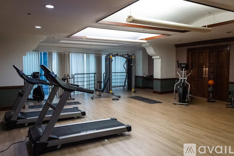 A gym with treadmills, weights, and exercise equipment.