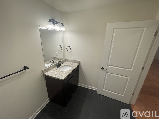 A bathroom with a sink, mirror, and a white door.