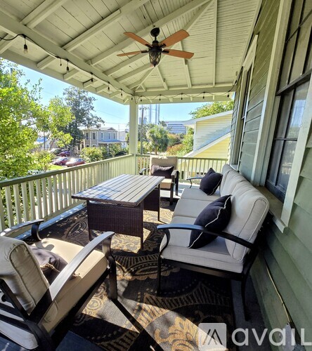 A patio with a table and chairs and a ceiling fan.