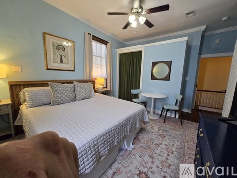 A bedroom with a large bed and a ceiling fan.