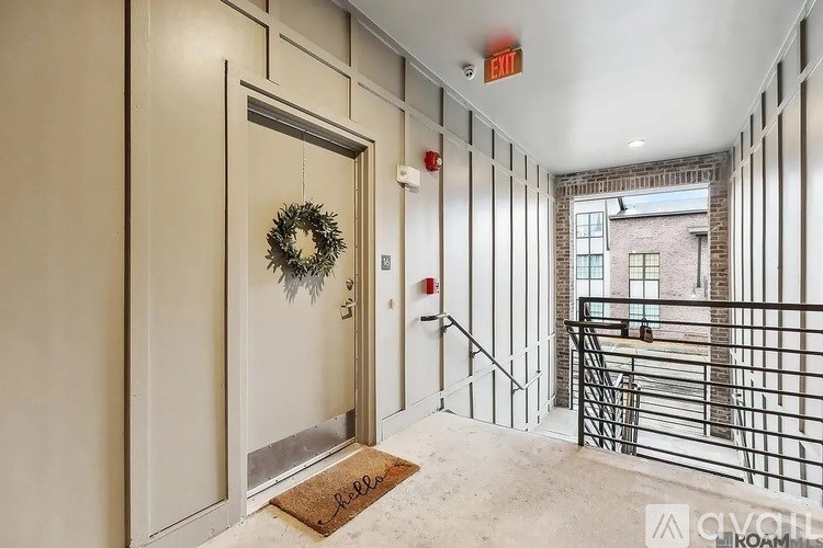 A hallway with a door and a wreath on the door.