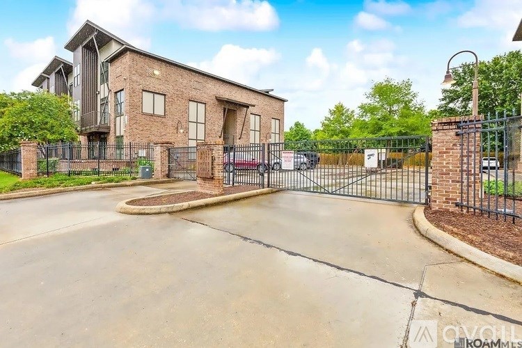 A gated entrance to a brick building with a clear sky in the background.