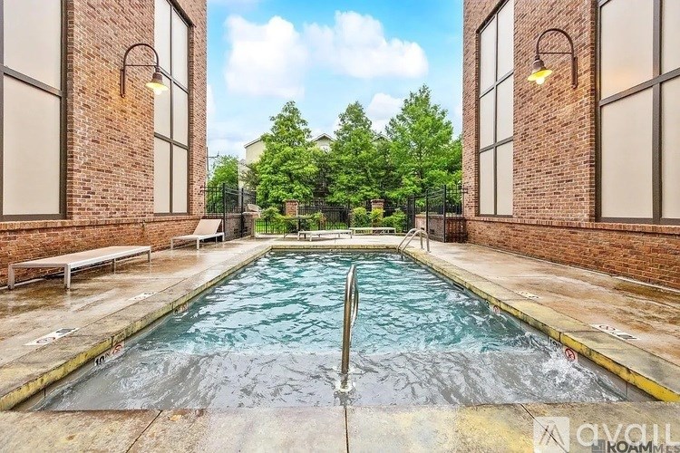 A pool surrounded by brick walls with a metal railing.