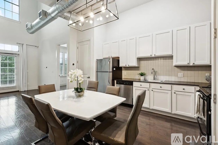 A modern kitchen with a dining table set for four.
