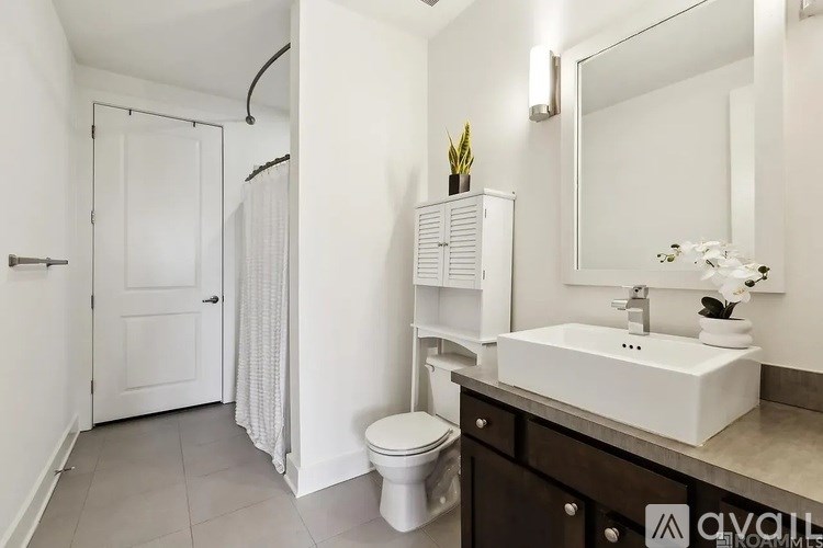 A white bathroom with a toilet, sink, and mirror.