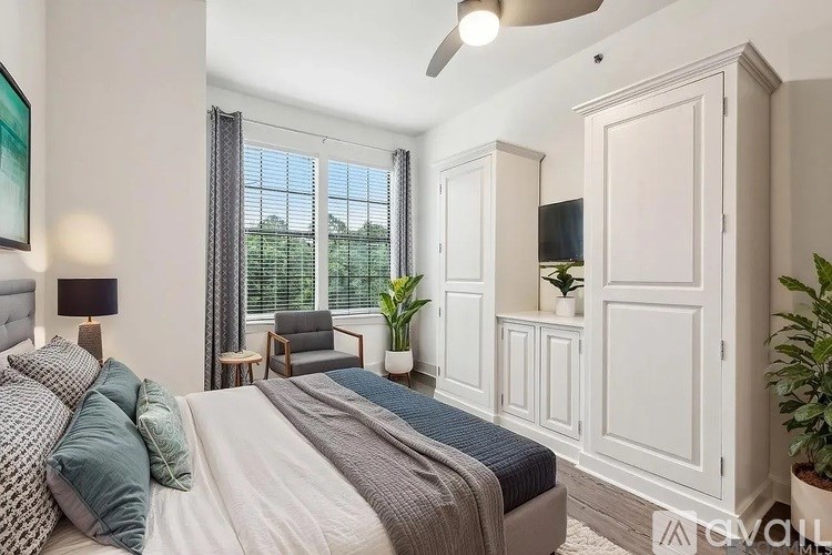 A bedroom with a large bed and a ceiling fan.