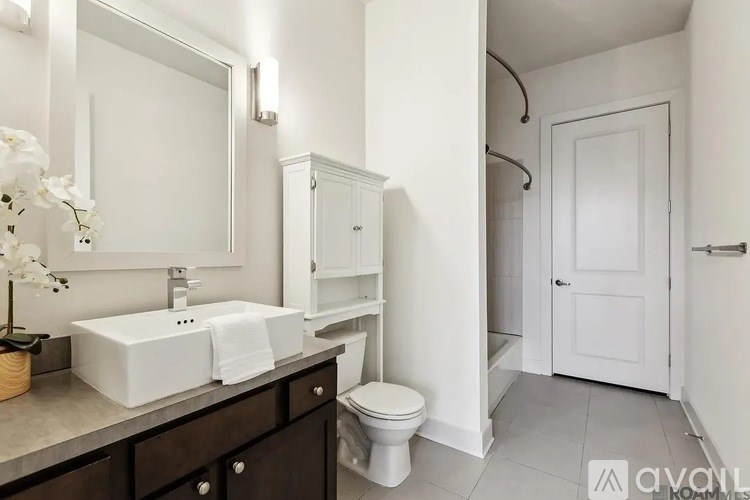 A white bathroom with a sink, toilet, and mirror.