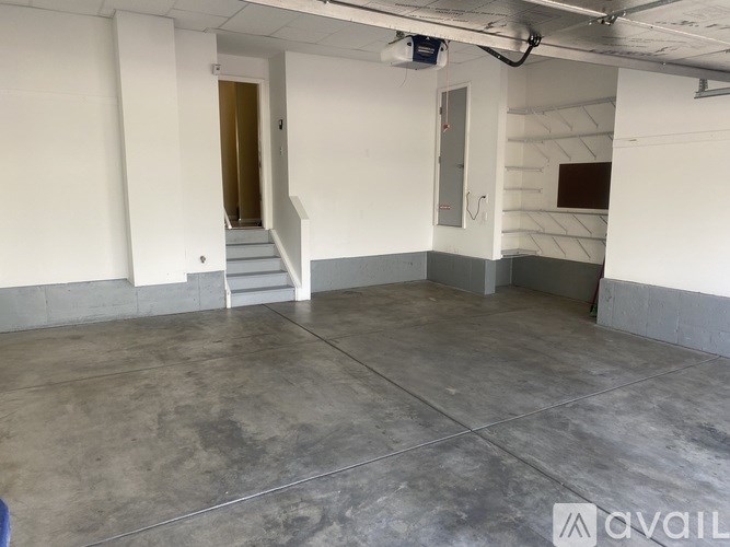 A room with a concrete floor and a staircase leading to another room.