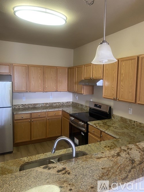 A kitchen with granite countertops and wooden cabinets.