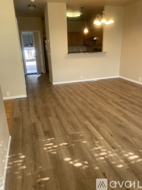 A room with wooden flooring and a mirror on the wall.